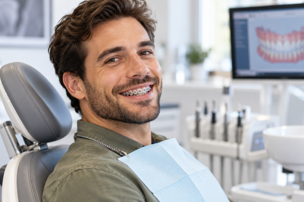 Smiling Patient with Braces in Dental Clinic